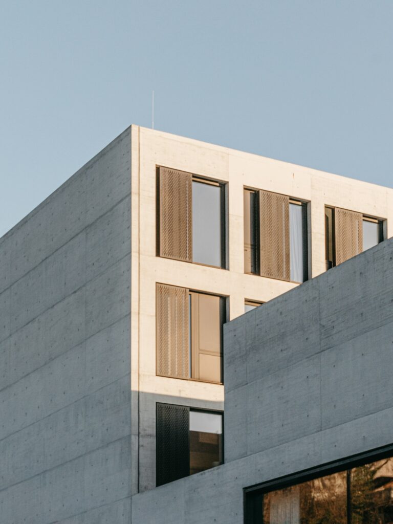 Family office investment strategies 2026: minimalist gray concrete high-rise building against a clear blue sky, representing institutional-grade wealth architecture