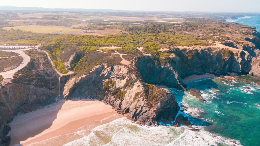 Aerial view of an undeveloped sandy coastline on India's Konkan coast, showing the high tide line that defines Coastal Regulation Zone boundaries