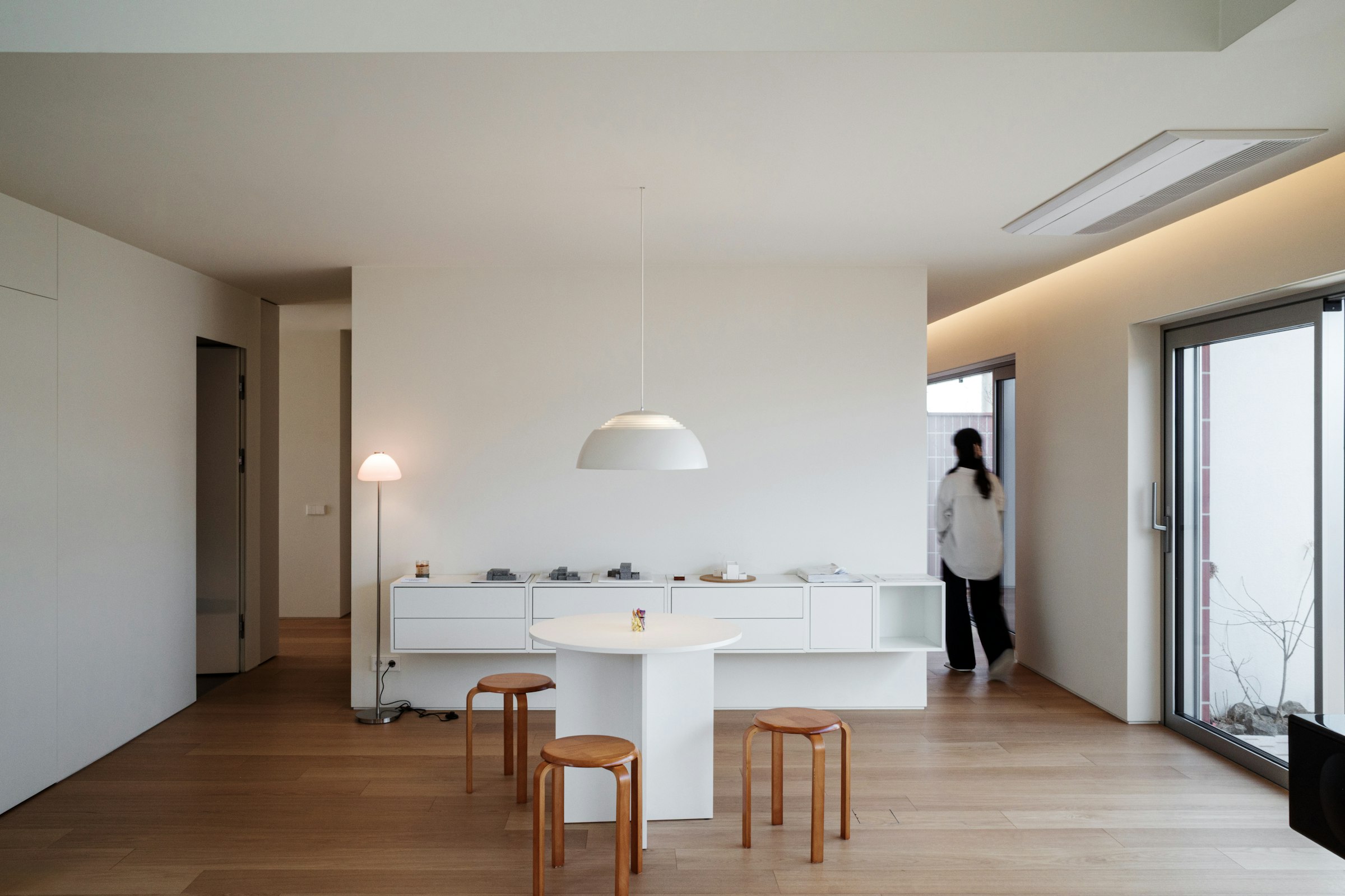 Minimalist private residence interior with natural light and a restrained material palette, reflecting understated quiet luxury design in wealth real estate